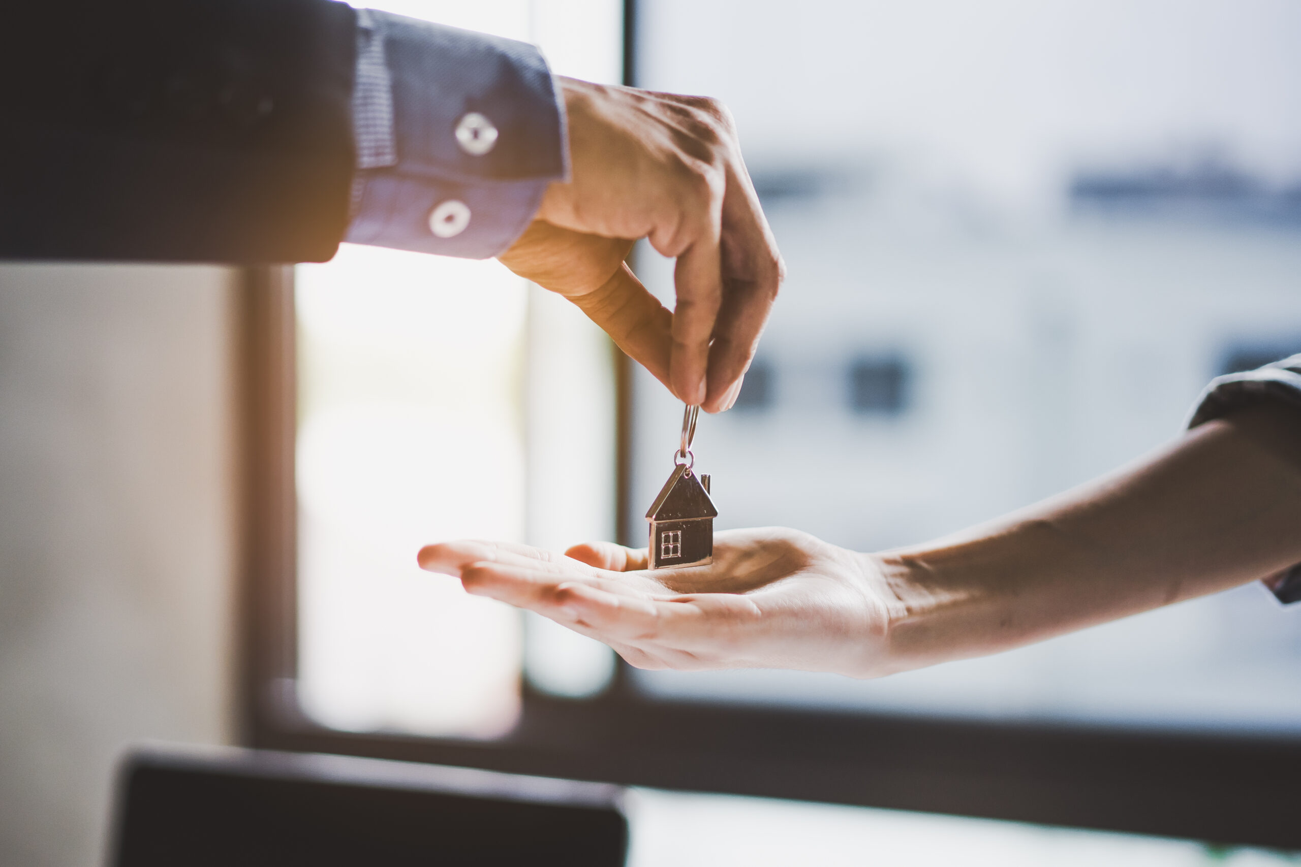close up view hand of property realtor / landlord giving key hou Ventes immobilières à